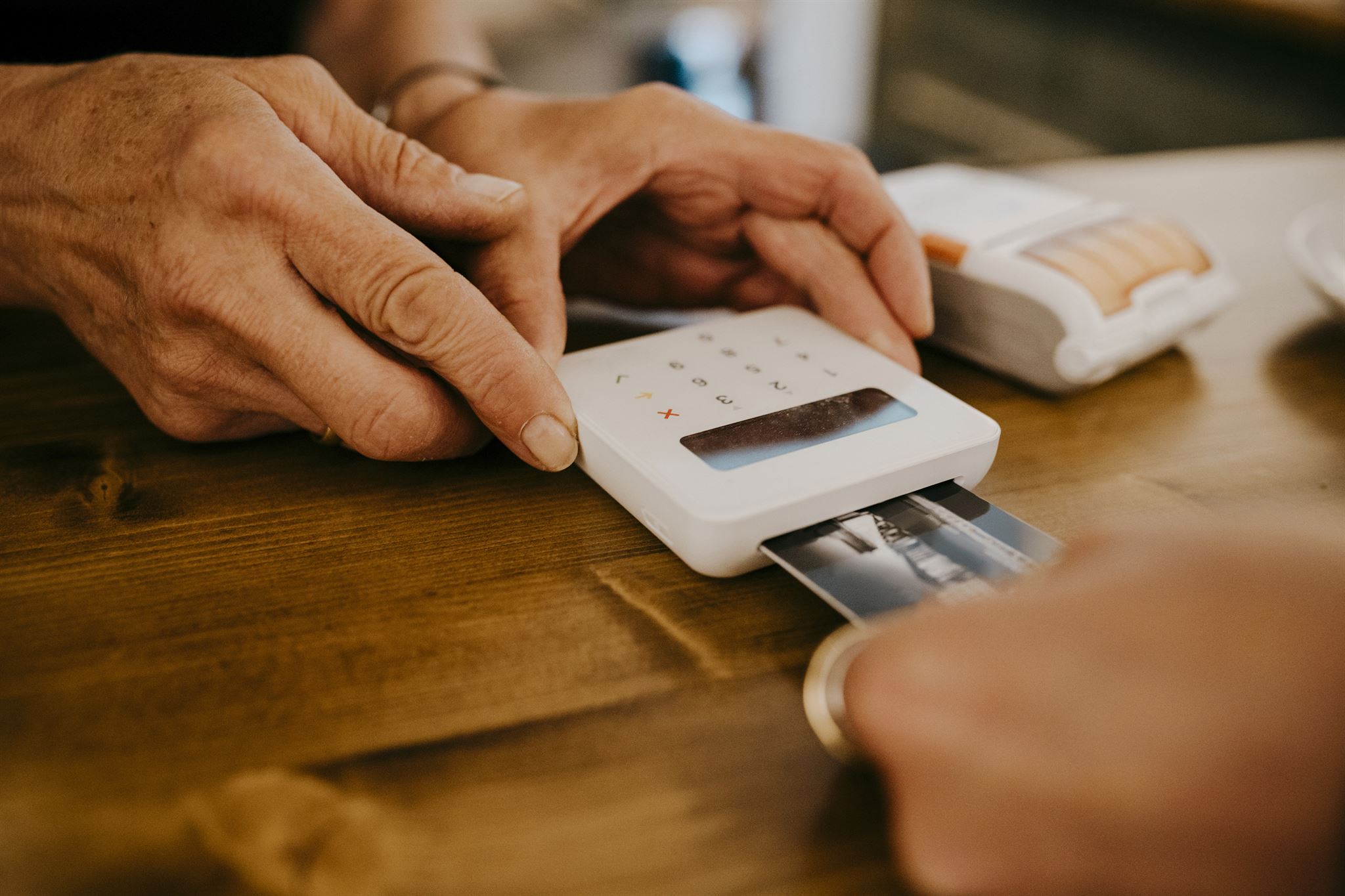 Hands-of-person-using-credit-card-reader